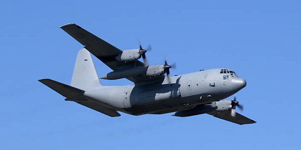 Military cargo plane in flight. C-130.